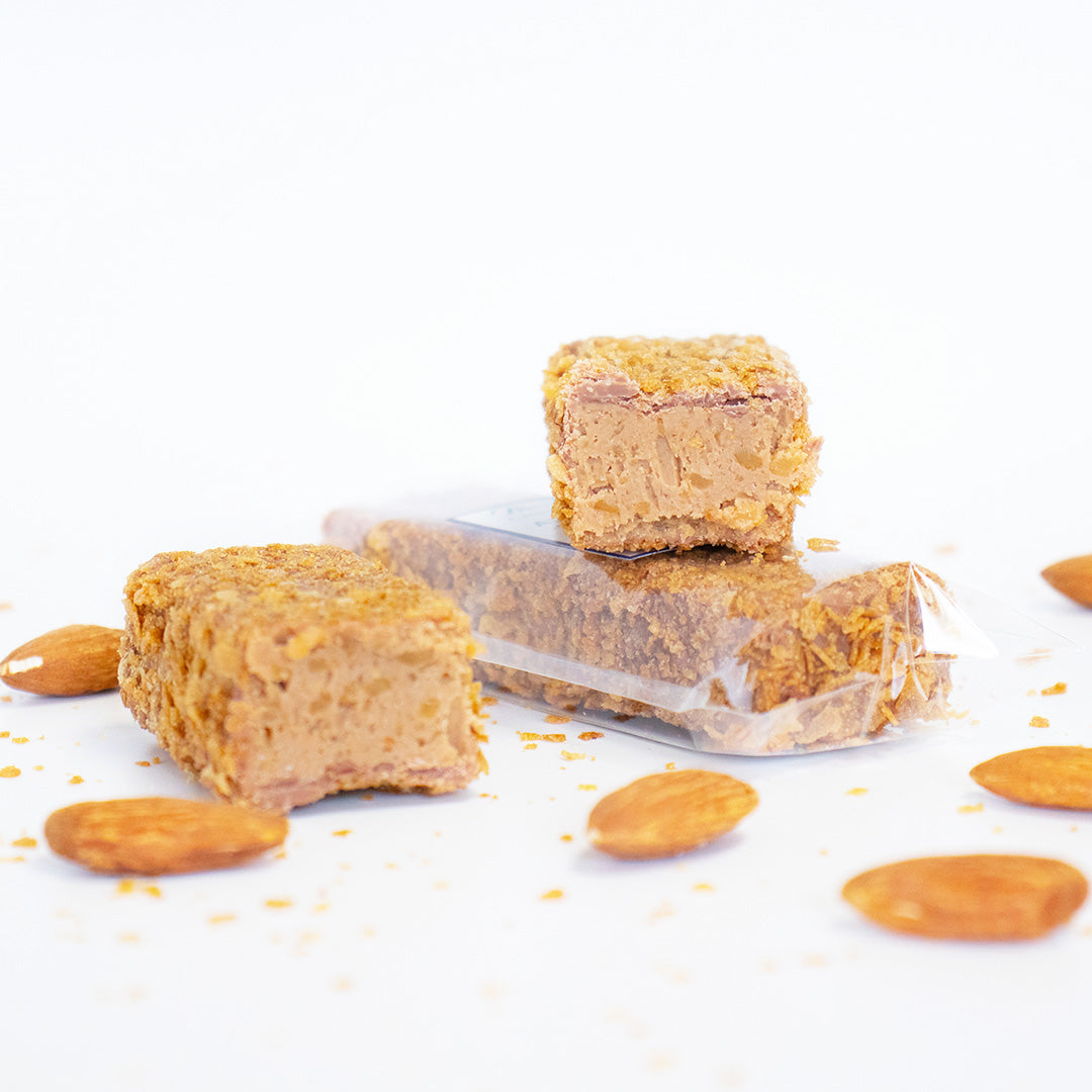 Nuts and a bar of a snack product on a white background