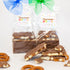 Two packages of Chocolate Pizazz candy with a stack of candy and pretzels on a white background.