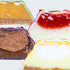 Close-up of layered dessert bars with different flavors on a white background