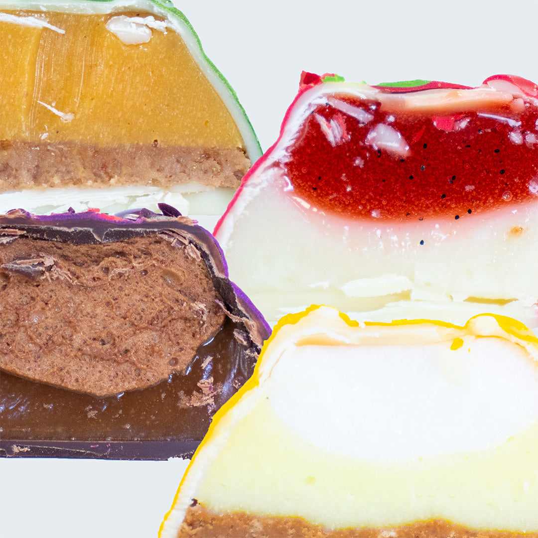 Close-up of layered dessert bars with different flavors on a white background