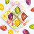 Colorful chocolate eggs in a decorative box with a floral design on a white background.