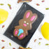 Chocolate bunny mold on a white surface with colorful candies around