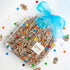 Box of chocolates with colorful candies and a blue ribbon on a white background