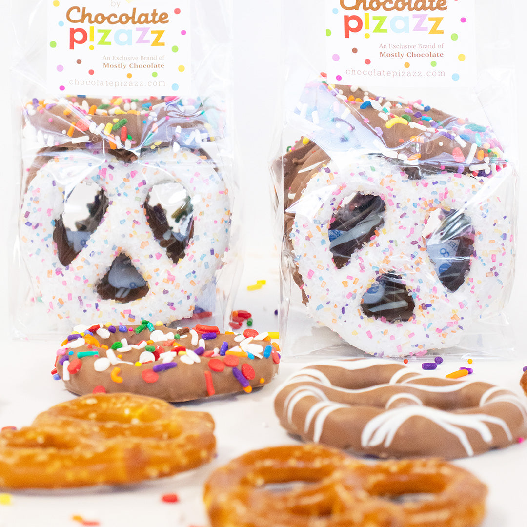 Two packages of chocolate covered pretzels with sprinkles on a white background, featuring 'Chocolate Pizazz' branding.