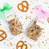 Two packages of chocolate-dipped pretzels with colorful ribbons on a white background.