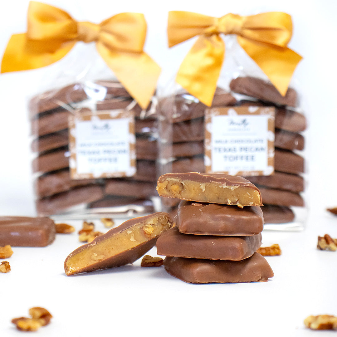 Chocolate-covered candies with a stack in front and wrapped candies with yellow bows in the background.