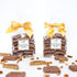 Two packages of Texas Pecan Toffee with yellow ribbons on a white background