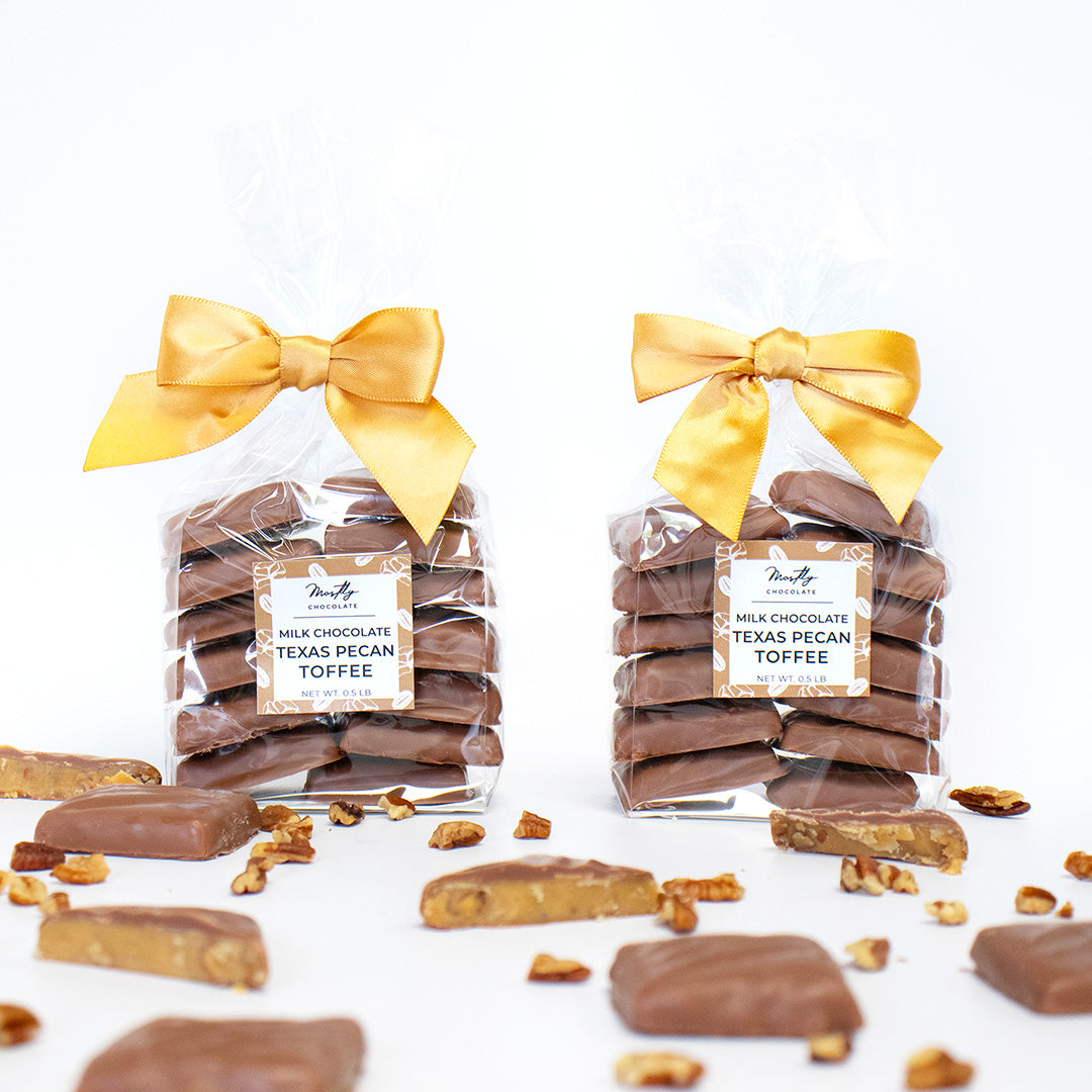 Two packages of Texas Pecan Toffee with yellow ribbons on a white background